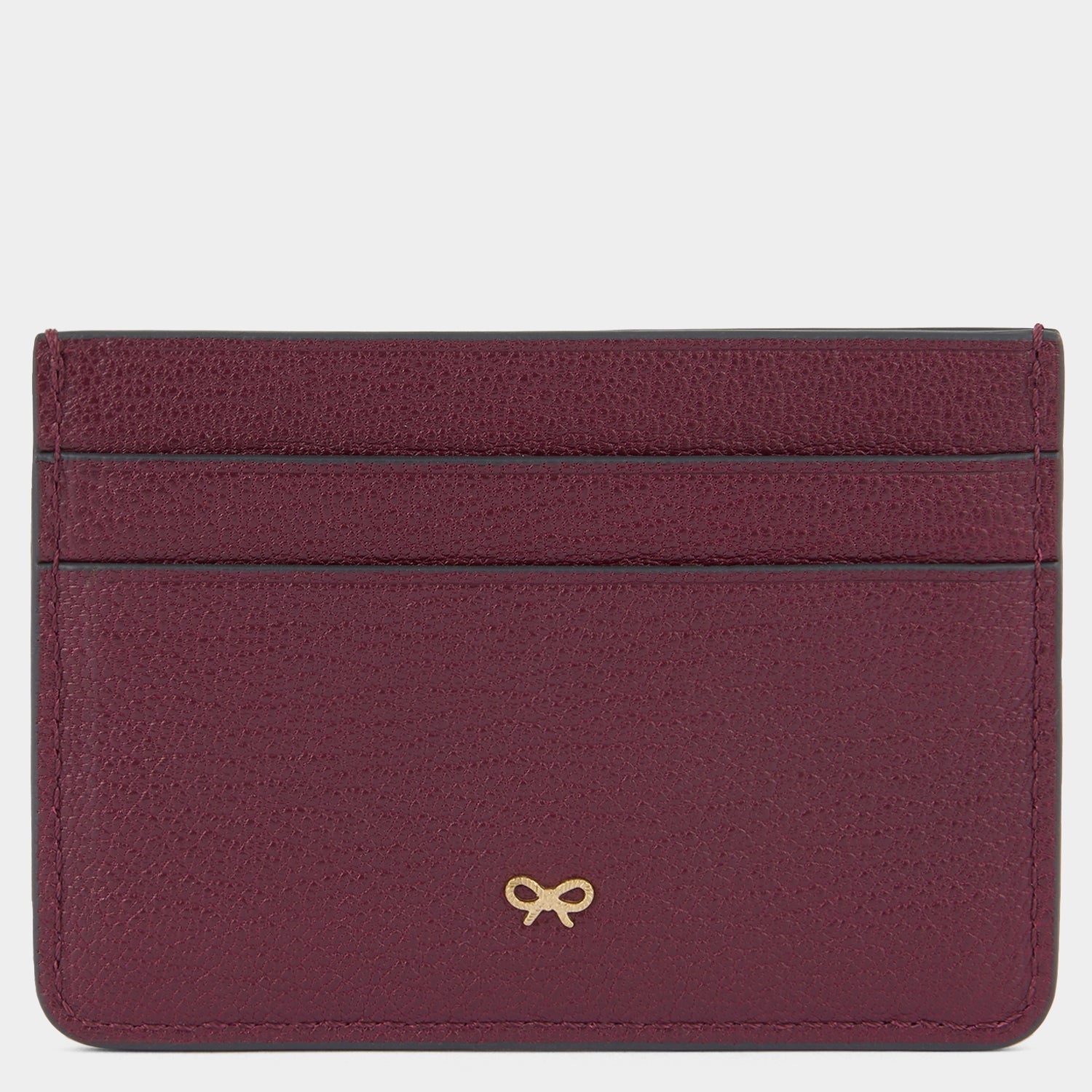 Purple card case with peeping eyes by Anya Hindmarch