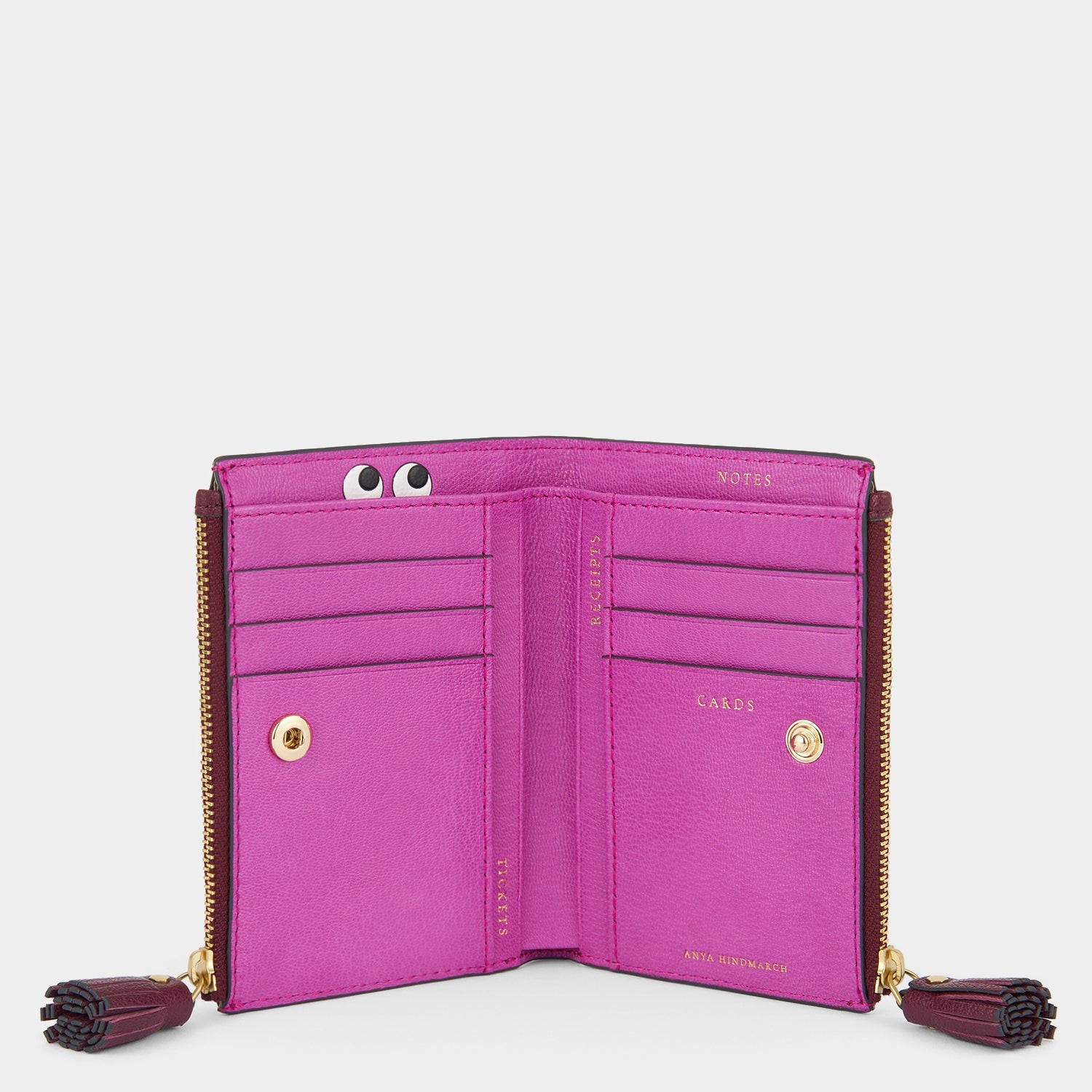 Purple double zip wallet with peeping eyes by Anya Hindmarch